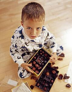 Boy into box of chocolates