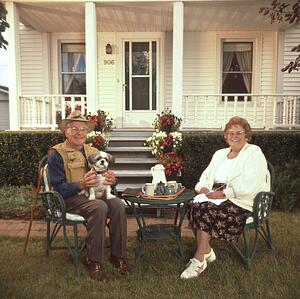 Senior couple relaxing in front of house