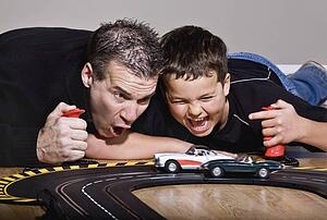 Father and son playing with race cars