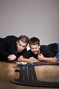 Father and son playing with toy race track