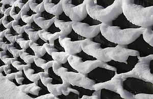 Fresh snow on a chain link fence