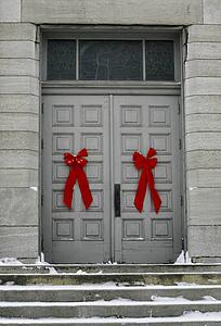 Red bows on doors of a grey building, Waterloo, Quebec