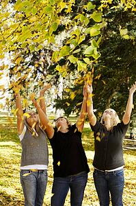 Girls throwing leaves in the air
