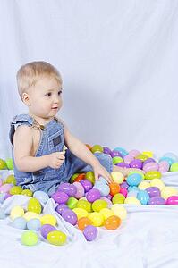Portrait of a baby surrounded by plastic Easter eggs
