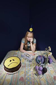 Upset girl surrounded by party supplies