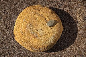 Large and small stone on sand