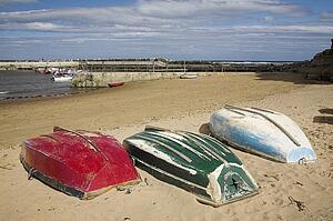 Three overturned boats on the beach, North Yorkshire, United Kingdom