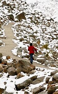 Walking along pathway among snow covered rocks