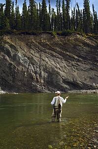 Man fly fishing in mountain river 