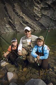 Father and sons in a mountain fly fishing river, Nordegg, Alberta, Canada 