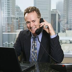 Male on phone in office with skyline in background