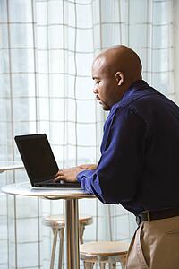 Male typing on laptop in computer