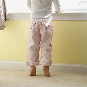 Girl standing on tip toes looking out window