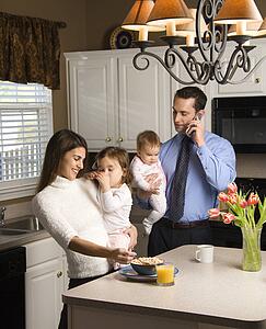 Family in kitchen busy with children and cellphone