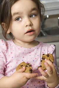 Girl eating chocolate chip cookie