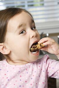 Girl eating chocolate chip cookie