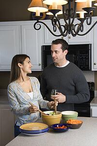Couple making salad at kitchen counter