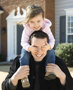 Father carrying daughter on shoulders