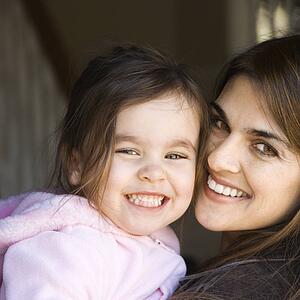 Mother holding daughter and smiling