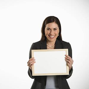 Portrait of mid adult professional business woman holding blank sign looking at viewer and smiling