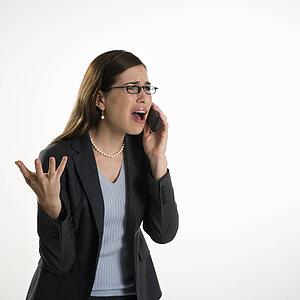 Professional business woman talking on cell phone with frustrated expression