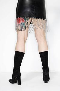 Back of adult caucasian female in leather dress.