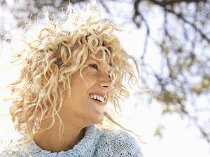 Woman with curly blonde hair smiling 