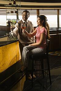 Mid adult man and woman toasting at bar