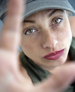Woman holding up hands and looking up at viewer