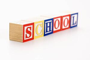 Alphabet toy building blocks spelling the word school.