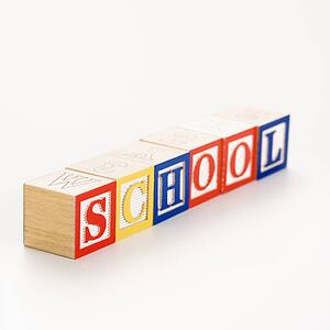 Alphabet toy building blocks spelling the word school.