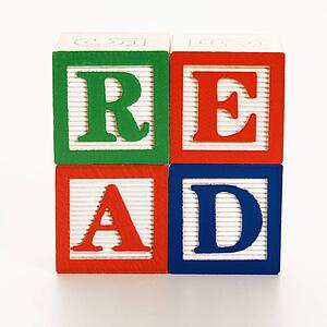 Stack of alphabet toy building blocks spelling the word read