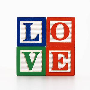Stack of alphabet toy building blocks spelling the word love.