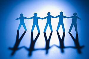 Cutout paper men standing holding hands.