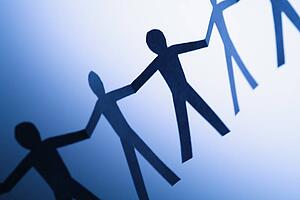 Cutout paper men standing holding hands