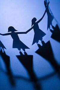 Cutout paper females standing holding hands