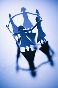 Cutout paper females standing in a circle holding hands