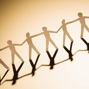 Cutout paper men standing holding hands