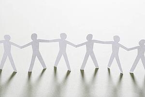 Cutout paper men standing holding hands