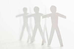 Cutout paper men standing holding hands