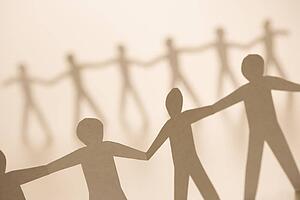Cutout paper men standing holding hands