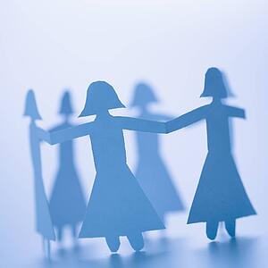 Paper cutout girls holding hands standing in circle