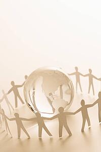 Cutout paper people standing around globe holding hands