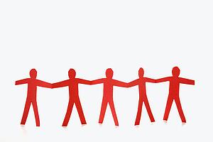 Red cutout paper men standing holding hands