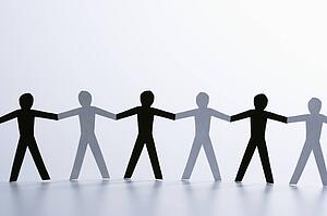 Black and white paper cutout men standing holding hands together
