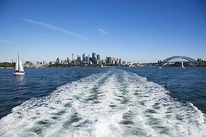 View from water of boats and skyline of Sydney, Australia.
