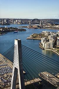 Aerial view of Anzac Bridge and buildings by harbour in Sydney, Australia.