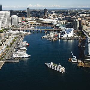 Aerial view of ships and boats in Darling Harbour with view of skyscrapers in Sydney, Australia.