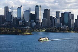 Aerial view ferryboat crossing harbour with skyline of Sydney, Australia.