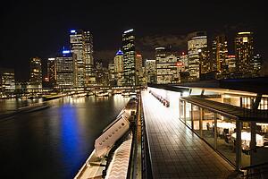 Night skyline with buildings and harbor in Sydney, Australia.